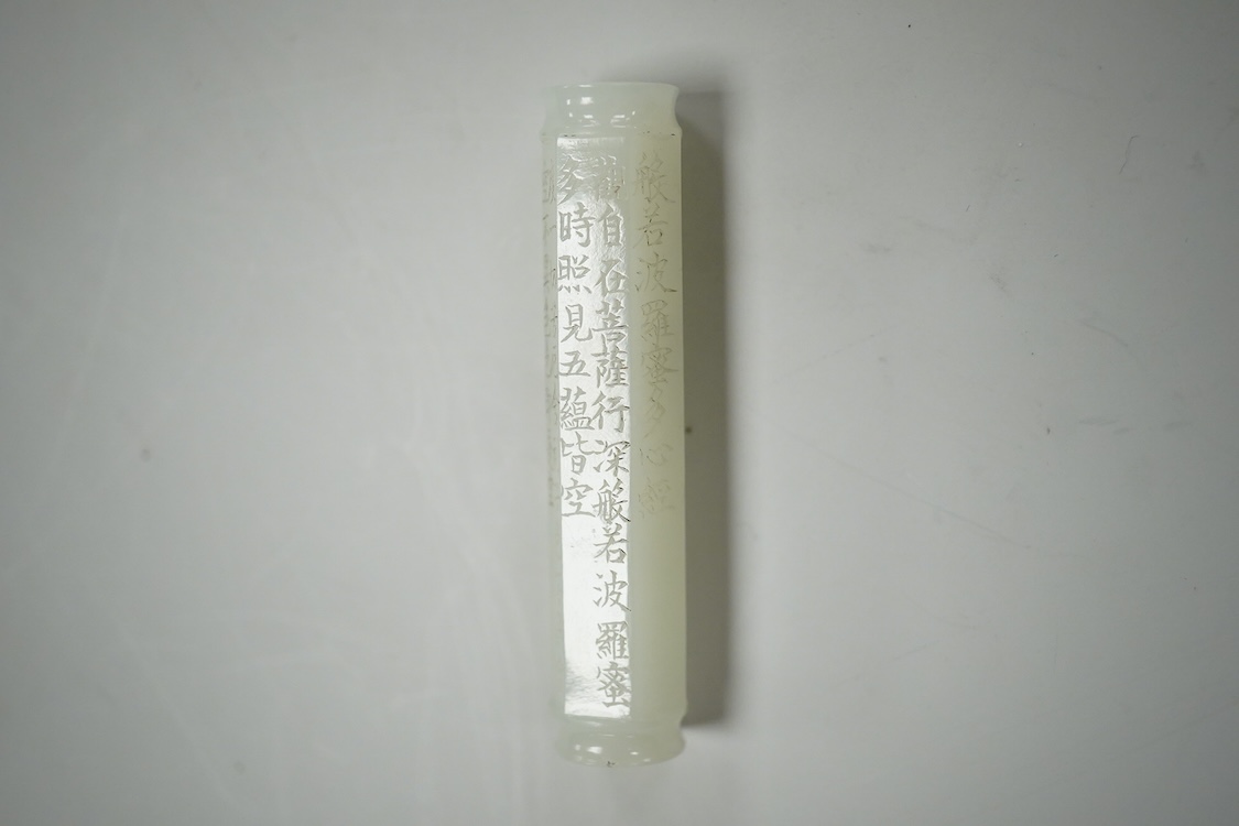 A Chinese pale celadon jade inscribed cylinder bead, 6.5cm long